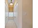 A hallway with a window, tiled floors, a ceiling light, and doors on each side at 65 Calumet Ave, Ponce Inlet, FL 32127