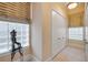 A hallway with a window, tiled floors, and doors on each side, including a sculpture on a table at 65 Calumet Ave, Ponce Inlet, FL 32127