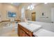 Well-lit bathroom features a jacuzzi tub and an expansive vanity with a sleek white countertop at 65 Calumet Ave, Ponce Inlet, FL 32127