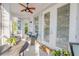 Inviting outdoor patio with comfortable seating, ceiling fan, and natural light streaming through the doors at 65 Calumet Ave, Ponce Inlet, FL 32127