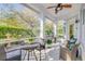 Relaxing screened patio featuring a seating area, ceiling fan, and a view of the lush backyard at 65 Calumet Ave, Ponce Inlet, FL 32127