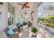 Comfortable screened patio featuring wicker seating, ceiling fans, and an outdoor garden view at 65 Calumet Ave, Ponce Inlet, FL 32127