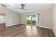 Bright bedroom features wood floors, neutral walls, fan, and sliding glass doors to the backyard at 711 Hiview Cir, Port Orange, FL 32127