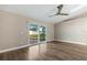 Bright bedroom features wood floors, neutral walls, fan, and sliding glass doors to the backyard at 711 Hiview Cir, Port Orange, FL 32127