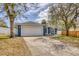 This home has a two-car garage, inviting front porch, and a driveway framed by mature trees at 711 Hiview Cir, Port Orange, FL 32127