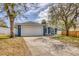This home has a two-car garage, inviting front porch, and a driveway framed by mature trees at 711 Hiview Cir, Port Orange, FL 32127