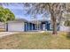 Charming blue home with a well-manicured lawn and mature tree in the front yard at 711 Hiview Cir, Port Orange, FL 32127