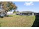 Large backyard with lush grass, mature trees, and an enclosed porch off the back of the home at 898 Glasgow Ave, Deltona, FL 32738