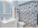 Bathroom with shower/tub combination and blue floral curtain, along with a large mirrored vanity at 898 Glasgow Ave, Deltona, FL 32738