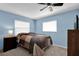 Bedroom with blue walls featuring a ceiling fan, two windows, and carpeted floors at 898 Glasgow Ave, Deltona, FL 32738