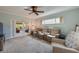 Comfortable living room featuring plush carpet, ceiling fan, and views of the sun room through glass doors at 901 Ponca Trl, Maitland, FL 32751