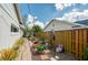 Side yard with stepping stone walkway and garden filled with potted plants and a wooden fence at 901 Ponca Trl, Maitland, FL 32751