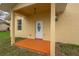 Back entrance of home featuring a concrete patio, white door with oval window, and siding at 926 Sycamore St, Daytona Beach, FL 32114
