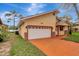 Single Gathering home featuring a two-car garage and charming front porch with decorative columns and a manicured lawn at 926 Sycamore St, Daytona Beach, FL 32114