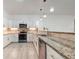 Updated kitchen featuring stainless steel appliances, granite countertops, and sleek cabinetry with designer pendant lights at 926 Sycamore St, Daytona Beach, FL 32114