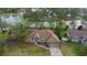 Aerial view of a home with a brown roof, surrounded by trees and a beautiful pond in the backyard at 1576 Naples Cir, Deltona, FL 32738