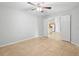 Neutral bedroom with tile flooring, a ceiling fan, and open doorway leading to other living spaces at 1576 Naples Cir, Deltona, FL 32738