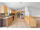 Spacious eat-in kitchen with tile flooring, stainless appliances, wood cabinets, and granite countertops at 1576 Naples Cir, Deltona, FL 32738
