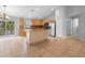 Bright kitchen with stainless steel appliances, center island, light wood cabinets, and tile floors at 1576 Naples Cir, Deltona, FL 32738