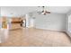 Spacious living room featuring tile flooring, a ceiling fan, and a seamless flow into the kitchen area at 1576 Naples Cir, Deltona, FL 32738