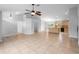 Open-concept living area featuring tile floors, a ceiling fan, and a view of the kitchen and entry at 1576 Naples Cir, Deltona, FL 32738