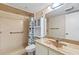Bathroom with a shower and bathtub combination, marble countertop sink, and storage cabinet at 1 Oceans West Blvd # 1B2, Daytona Beach, FL 32118