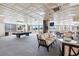 Bright game room with a pool table, comfortable seating, and large windows overlooking lush landscaping at 1 Oceans West Blvd # 1B2, Daytona Beach, FL 32118