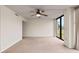 Empty living room with a ceiling fan and large windows, providing natural light at 1 Oceans West Blvd # 1B2, Daytona Beach, FL 32118