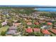 An aerial view showcasing homes with orange tile roofs nestled among lush trees and tranquil community lakes at 100 Via Rosa Ct, Debary, FL 32713