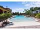 Beautiful community pool area featuring lounge chairs and tropical landscaping for relaxing by the water at 100 Via Rosa Ct, Debary, FL 32713