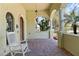 Charming front porch with brick flooring, white rocking chair, and columns, creating a welcoming entrance at 100 Via Rosa Ct, Debary, FL 32713