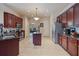 Well-lit kitchen with an island, tile floors, stainless steel appliances, and wooden cabinets at 100 Via Rosa Ct, Debary, FL 32713