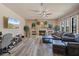 Bright living room features a fireplace, ceiling fan, neutral walls, wood floors, and many windows at 100 Via Rosa Ct, Debary, FL 32713