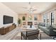 Bright living room features a fireplace, ceiling fan, neutral walls, wood floors, and many windows at 100 Via Rosa Ct, Debary, FL 32713