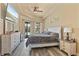 Bright main bedroom featuring a tray ceiling, wood floors, ensuite bathroom and access to pool area at 100 Via Rosa Ct, Debary, FL 32713