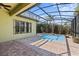 View of a screened-in pool surrounded by brick pavers, landscaping, and a house in the background at 100 Via Rosa Ct, Debary, FL 32713