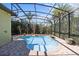 View of a screened-in pool surrounded by brick pavers, landscaping, and a house in the background at 100 Via Rosa Ct, Debary, FL 32713