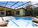 View of a screened-in pool surrounded by brick pavers, landscaping, and a house in the background at 100 Via Rosa Ct, Debary, FL 32713
