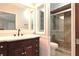Bathroom vanity featuring wood cabinets, a light countertop, mirror, and a glass-enclosed tiled shower at 1013 Matterhorn St, Deltona, FL 32725