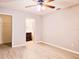 Bright bedroom with light wood floors, ceiling fan, closet, and an ensuite bathroom for convenience at 1013 Matterhorn St, Deltona, FL 32725