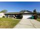 Single-story brick home with a well-manicured lawn, blue shutters, and an attached two-car garage at 1013 Matterhorn St, Deltona, FL 32725