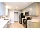 Well-lit kitchen with gray cabinets and stainless steel appliances at 1013 Matterhorn St, Deltona, FL 32725