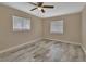 Cozy bedroom with ceiling fan, two windows, and wood-look tile flooring at 1033 Windbrook Dr, Deltona, FL 32725