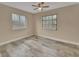 Sunny bedroom with two windows, a ceiling fan, and attractive wood-look tile flooring at 1033 Windbrook Dr, Deltona, FL 32725