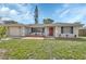 Charming single-story home with a red front door and manicured landscaping at 1033 Windbrook Dr, Deltona, FL 32725