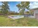 Backyard with a private in-ground pool, surrounded by well-maintained grass and mature trees, perfect for summer enjoyment at 1033 Windbrook Dr, Deltona, FL 32725