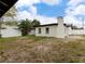 A view of the backyard featuring the home's exterior, a privacy fence, and some trees at 1135 Holly Ave, Daytona Beach, FL 32117