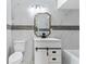 Bathroom features marble tiling, white vanity with a black faucet, mirror, and modern light fixture at 1135 Holly Ave, Daytona Beach, FL 32117