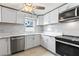 Modern kitchen features white cabinets, stainless steel appliances, and stylish countertops, creating a sleek and functional space at 1135 Holly Ave, Daytona Beach, FL 32117