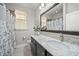 Bathroom with a granite counter, dark wood cabinets, and large framed mirror at 118 Grande Belfly Way, Daytona Beach, FL 32124